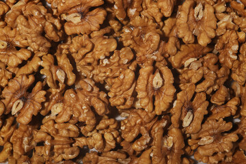 Heap of raw walnuts close-up as background.