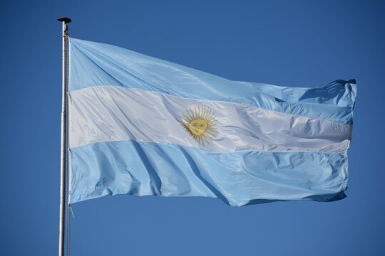 Bandera de la Rep&uacute;blica Argentina de tela flameando en el cielo celeste