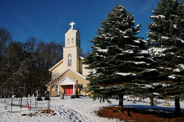 St. Paul's Evangelical Lutheran Church in pine trees on a winter day. The view from Orange hiking trail around the golf course in North Park, Allegheny County, near Pittsburgh, Pennsylvania, USA