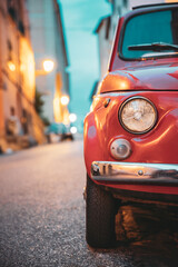 Close Up Headlight Of Old Small Funny Vintage Retro Red Car In Evening Night