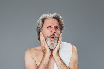 Fresh and clean face. Stylish modern senior man with gray hair and beard is indoors