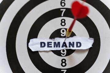 A piece of paper with the text is nailed to the target with a dart - DEMAND