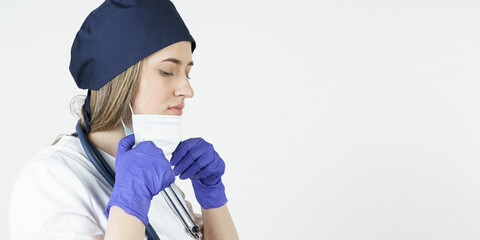 Medicine and health concept. Portrait of a young female doctor who takes off her mask.