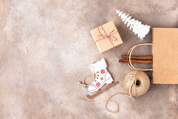 Fototapeta na wymiar Zero waste and eco christmas concept. ball of twine, gift box, craft paper, fir tree and ski on beige brown background. 