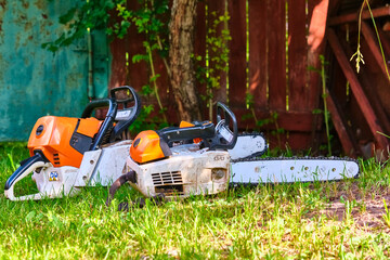 two professional gasoline saws on the grass. general plan