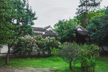 Traditional Chinese architecture between trees at Lingering Garden Scenic Area, Suzhou, Jiangsu, China