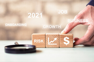 Businessman hand arranging wood block with dollar icon. Business growth and onboarding in 2021 Concept.