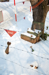 Landmines sign, danger minefield with mines and projectiles in the background