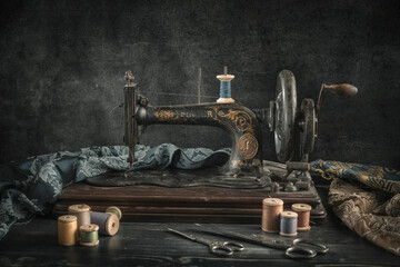 Fototapeta na wymiar The sewing machine and accessories - threads, needle, scissors, measuring tape.