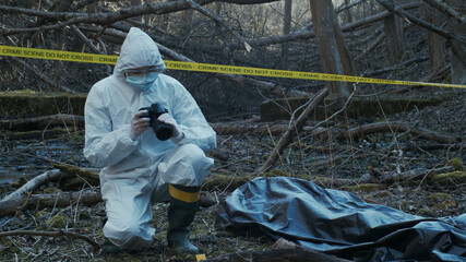 Detectives are collecting evidence in a crime scene. Forensic specialists are making expertise. Police investigation in a forest.