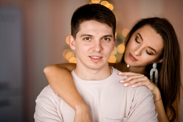 portrait of young man and beautiful woman who hugs his neck