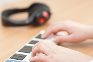 Close up of hands playing on a Korg nanoKEY MIDI controller keyboard