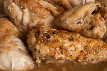 Close-up of chicken in vegetable sauce with cognac.  Meat, and vegetables. Organic texture background.