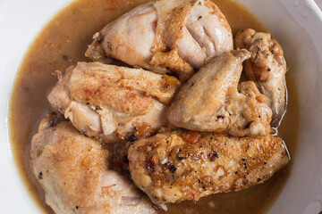 Overhead view of a plating food of chicken food in vegetable sauce with cognac in a ceramic dish. Recipes of meat and vegetables.