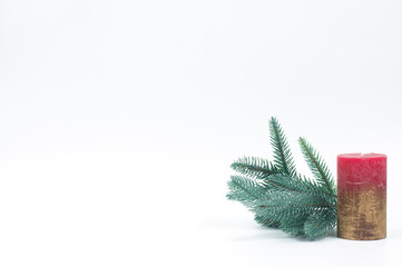 Candles and a twig of a Christmas tree on a white background.
