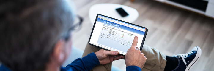 Man Using Tablet Computer Checking Bank Statement
