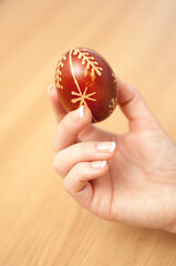 Woman hands holding dyed traditional easter eggs with handmade patterns