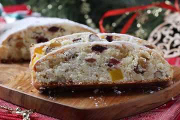 Christmas tasty stollen with dry fruits, berries and nuts on wooden board. Traditional German treats.