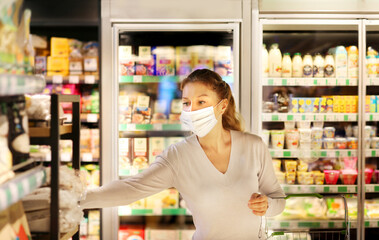 supermarket shopping, face mask,Woman choosing a dairy products at supermarket.