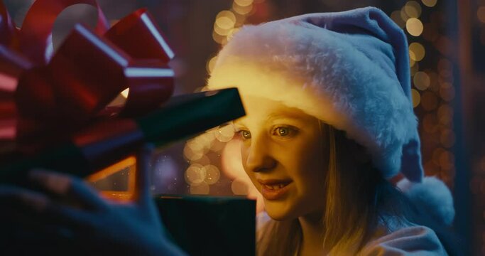 Amazed girl examining magic Christmas present