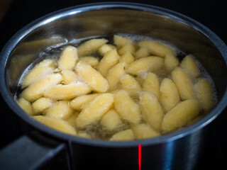 Dumplings cooking in hot water in pot 