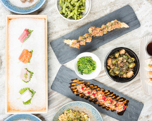 Sushi, sashimi and other asian cuisine selections elegantly displayed on a marble table top