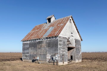 Old Barn by a Farm Field under a Clear Blue Sky