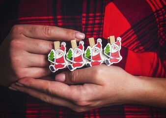 Christmas toys in the hands of a girl. Images of Santa Claus on a toy