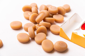 Pack with brown candies on white table.