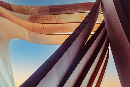 Futuristic urban architecture. Art arch vertical triangles made of brown tin metal with a blue sky background. Abstract backdrop. Selective focus. Copy space.