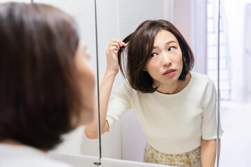 鏡を見る女性　髪の毛