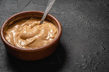 postre mezcla de crema con dulce de leche con cuchara sobre base gris para hacer chocotorta o...