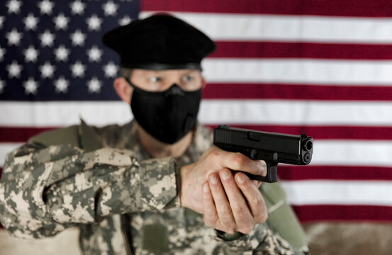 Armed military man aiming weapon while wearing mask for protection against the coronavirus