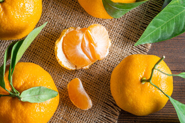 Fresh ripe juicy yellow mandarin ( clementine, tangerine ) on rustic vintage table with leaf. Winter fruit background concept