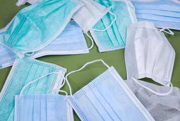 Different surgical masks on light green background