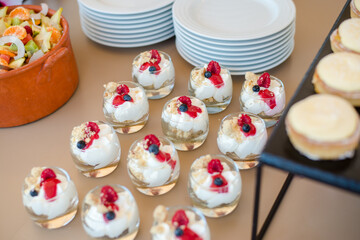 The catering wedding buffet for events. Wedding reception dessert table with delicious decorated white cupcakes.