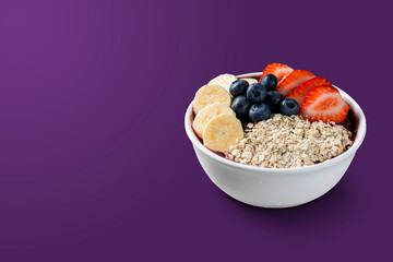 Brazilian frozen açai berry ice cream bowl with strawberries, bananas, blueberry and granola. isolated on purple background. Summer menu front view