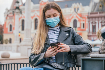 Woman wearing face mask and using her smartphone