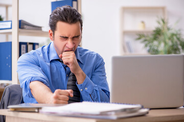 Naklejka premium Young businessman employee unhappy with excessive work in the o