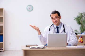 Young male doctor lecturer cardiologist working in the clinic