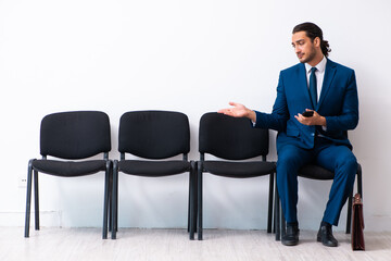 Young businessman waiting for an interview at hall