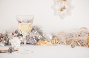 A glass of Champagne and Christmas decorations on a white background