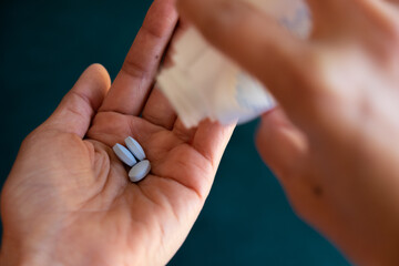 person pouring pills into hand