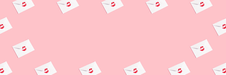 Red lipstick kiss on white envelope on pink pastel background. Minimal correspondence concept. Love letter. Banner for website.