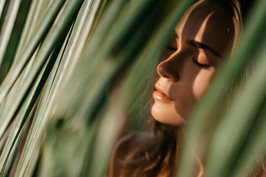 portrait of tender woman looking out of palm leaf Bali Indonesia
