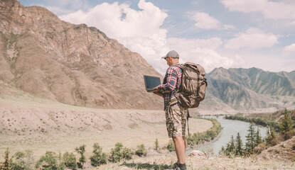 person in the mountains with laptop