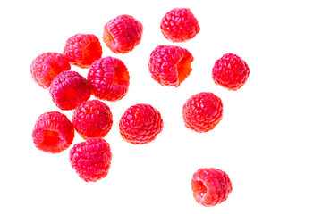 A scattering of red raspberries with a backlight on a white background
