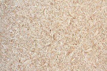 Wooden sawdust as background. Natural texture of pressed sawdust. Pieces of wood chips.