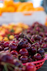 a portrait of cherries in basket in a farmer market