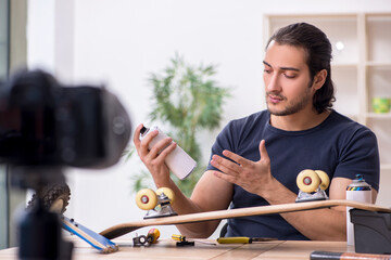 Young male skateboarder repairman recording video for his blog